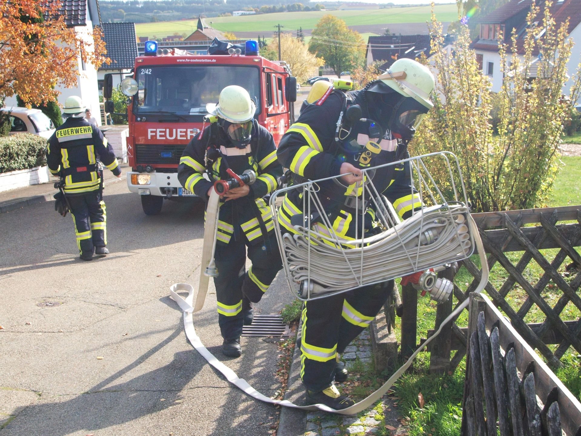 Feuerwehrleute mit einem Schlauchtragekorb bei der Hauptübung in Söhnstetten auf dem Weg zum „Brandplatz“. 