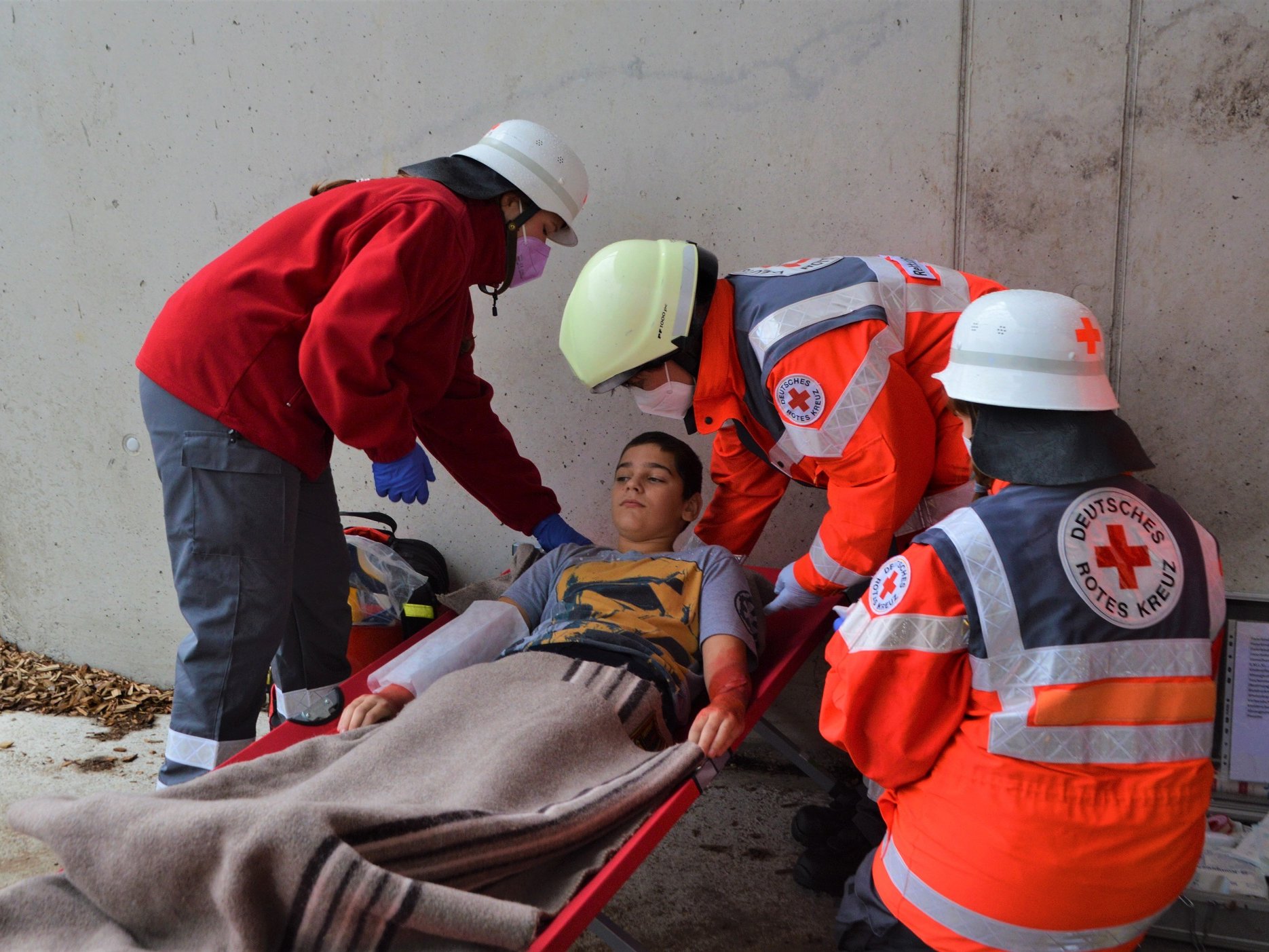 Helferinnen und Helfer der Rot-Kreuz Bereitschaft Steinheim versorgen einen „Verletzten“, vor der Übung wurde die Wunden speziell geschminkt.